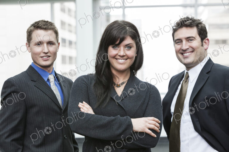 A group portrait of three business people, with a caucasian woman as the lead.