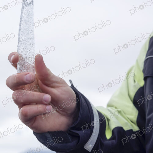 A guide holding an ice core sample from the Glacial Lagoon in his hand.