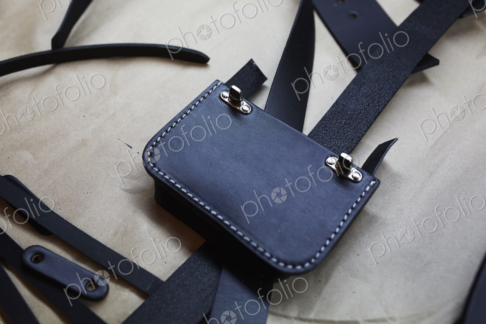 A handmade blue leather bag, strap, component part parts, scissors and hand tools.