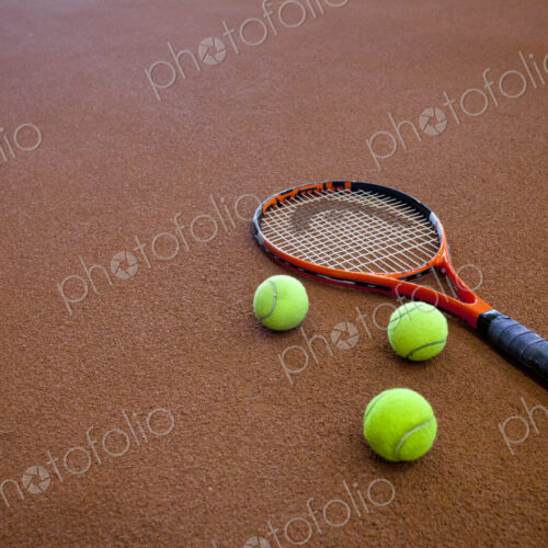A hard tennis court and a tennis raquet,with three balls. A hard tennis court and a tennis raquet,with three balls.