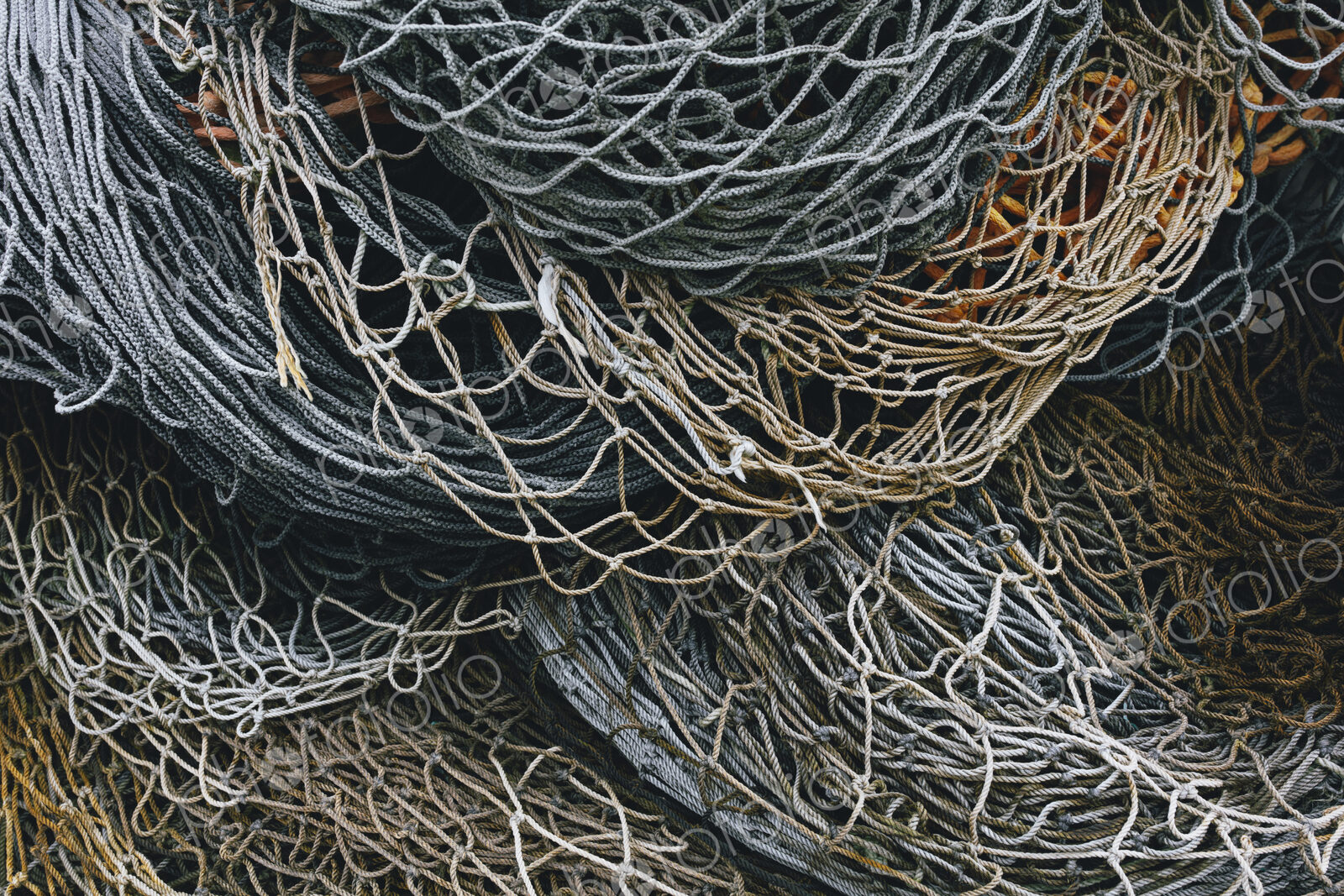 A heap of commercial fishing nets on the quayside.