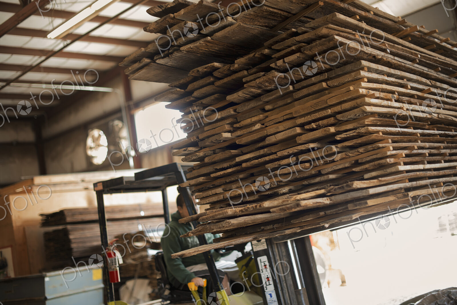 A heap of recycled reclaimed timber planks of wood being moved on a forklift truck.…