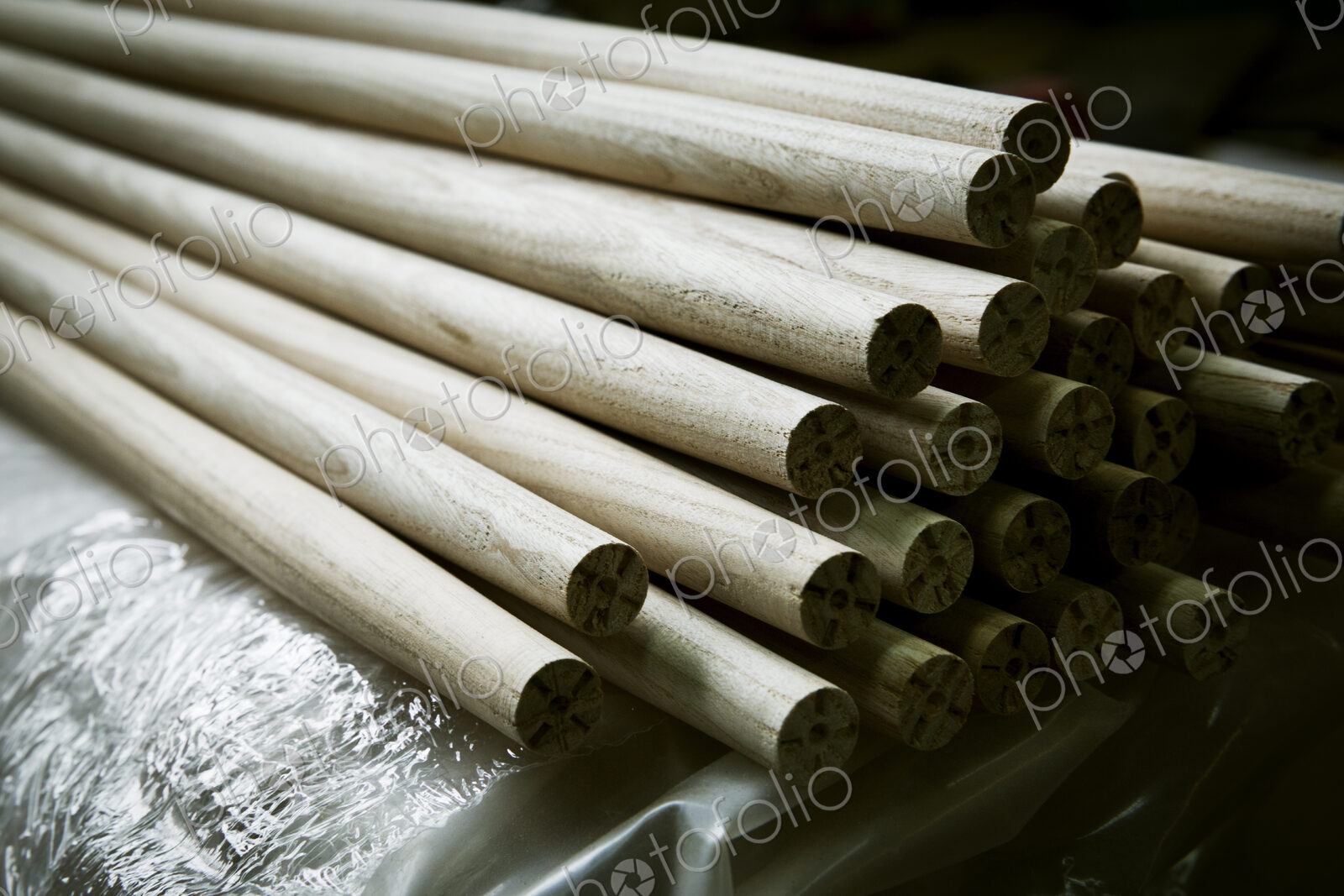 A heap of round smooth wooden poles or components of a wooden chair.