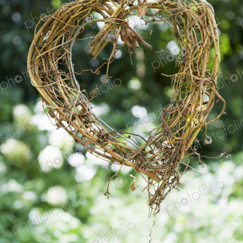 A heart shape made out of woven twigs, hanging from a tree. Simple decorations. A heart shape made out of woven twigs, hanging from a tree. Simple decorations.