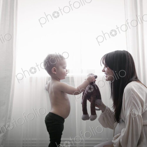 A heavily pregnant woman playing with her young son. A heavily pregnant woman playing with her young son.