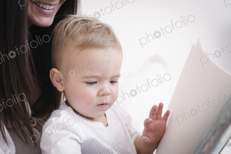 A heavily pregnant woman playing with her young son.
