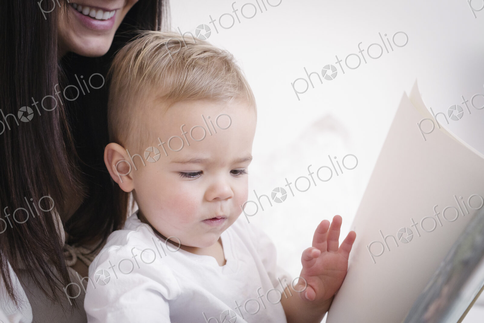 A heavily pregnant woman playing with her young son.