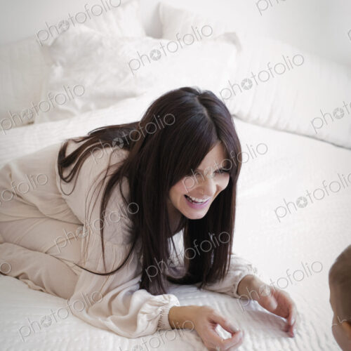 A heavily pregnant woman playing with her young son.