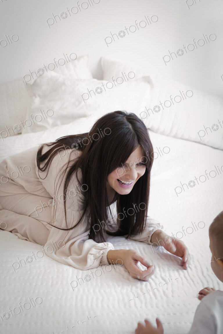 A heavily pregnant woman playing with her young son.