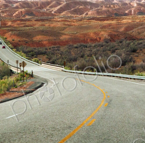 A highway going through a desert with rock formations in southern Utah A highway going through a desert with rock formations in southern Utah