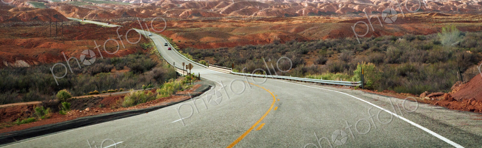 A highway going through a desert with rock formations in southern Utah
