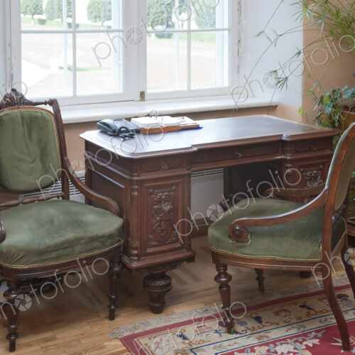 A historic house, antique furniture by a window, a desk and two chairs, window and… A historic house, antique furniture by a window, a desk and two chairs, window and…