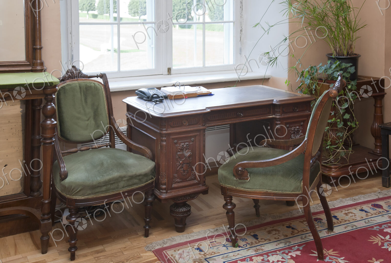 A historic house, antique furniture by a window, a desk and two chairs, window and…