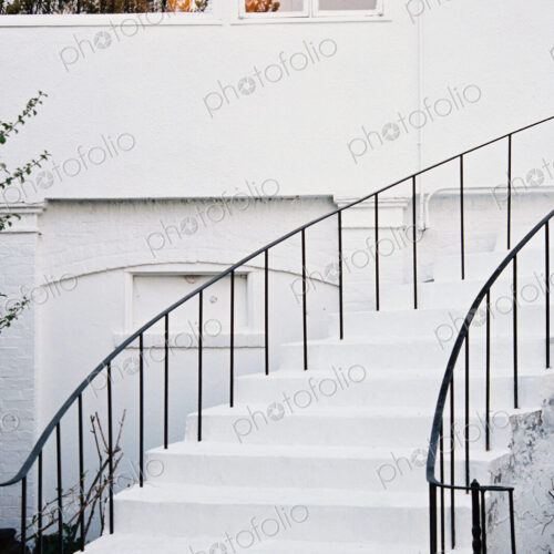 A historic late 18th century house with white walls and a curved exterior staircase A historic late 18th century house with white walls and a curved exterior staircase