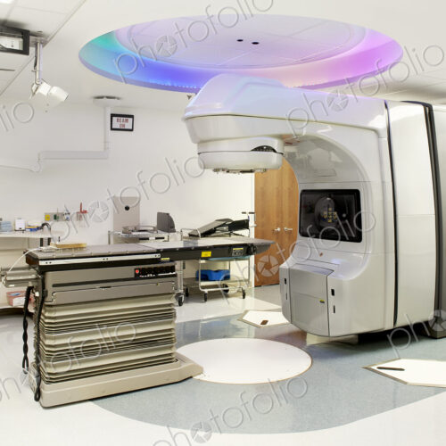 A hospital treatment room in a radiology department, with a scanning or imaging machine.