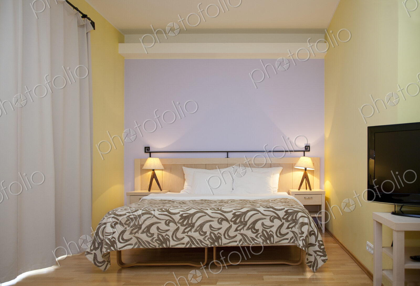 A hotel bedroom, modern furniture and fittings, double bed and bedside lights,…