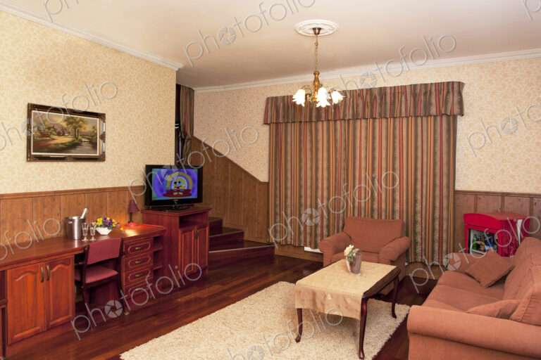 A hotel with old fashioned retro styled rooms, and rustic objects, sofa and chairs and…