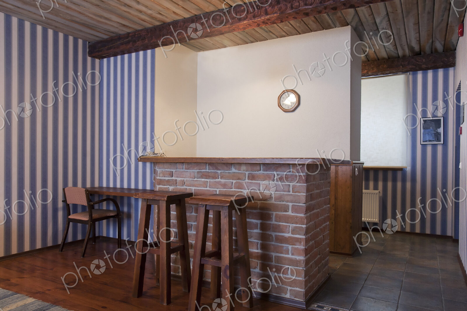 A hotel with old fashioned retro styled rooms, bar with two bar stools and striped…