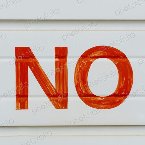 A large NO sign in red paint on a garage door, indicating No Parking. A large NO sign in red paint on a garage door, indicating No Parking.