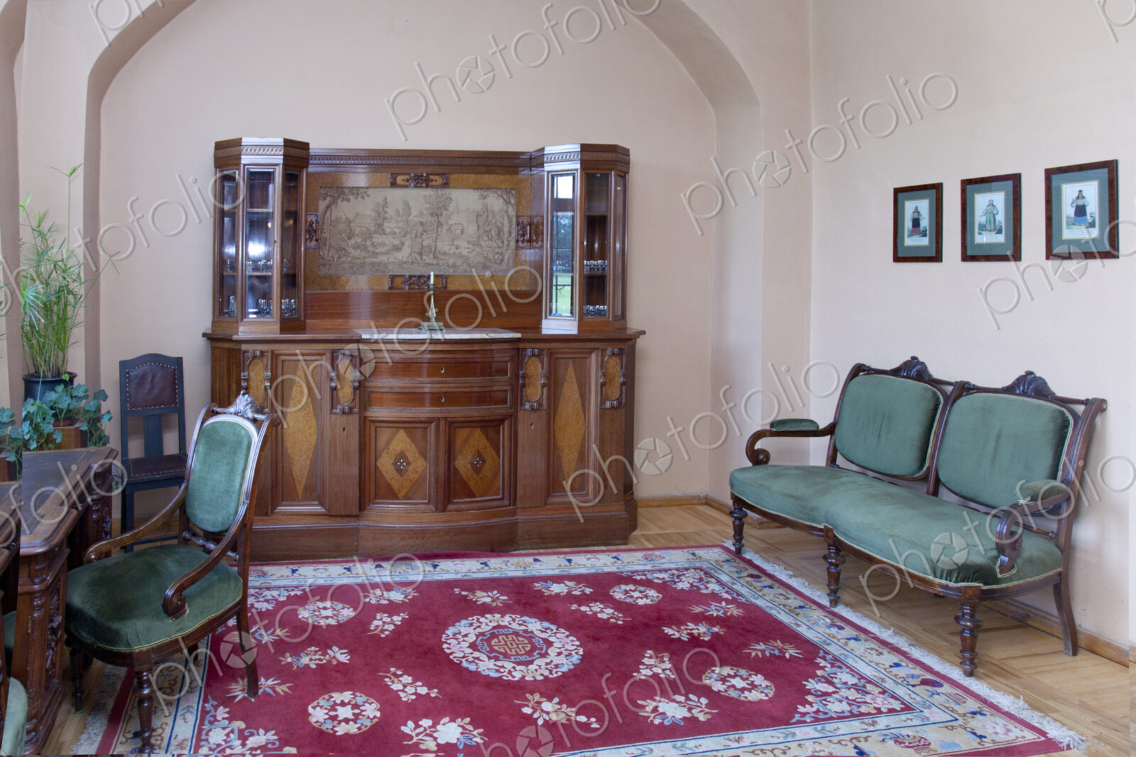 A large antique display cabinet, storage, a carpet and antique style chairs and desk…