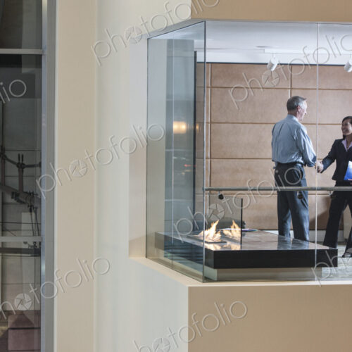 A large building, lobby, view looking into an office with glass walls, two business… A large building, lobby, view looking into an office with glass walls, two business…