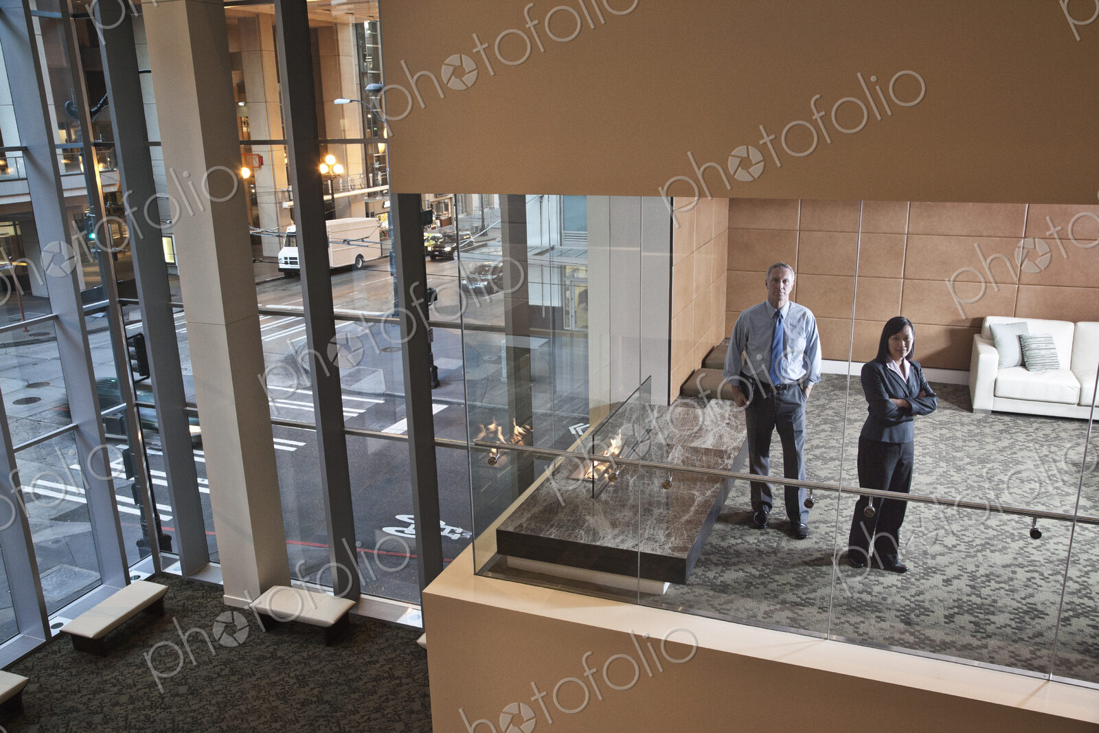 A large building, lobby, view looking into an office with glass walls, two business…
