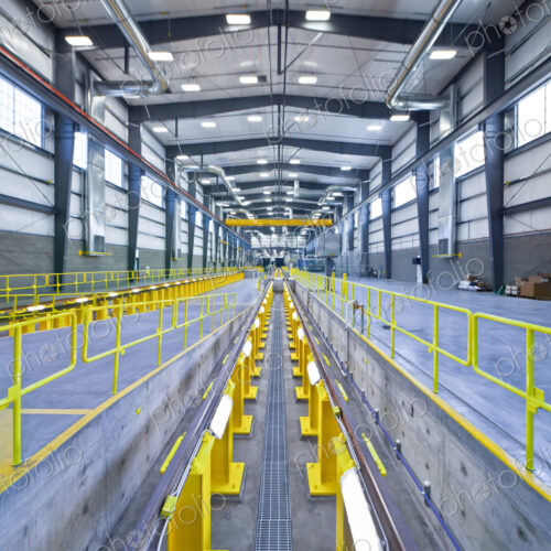 A large covered maintenance yard on a railway, an elevated rail avobe a pit for… A large covered maintenance yard on a railway, an elevated rail avobe a pit for…