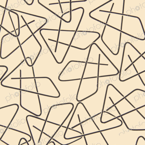A large group of objects, a type of paperclip, metal bent into a butterfly shape on a…