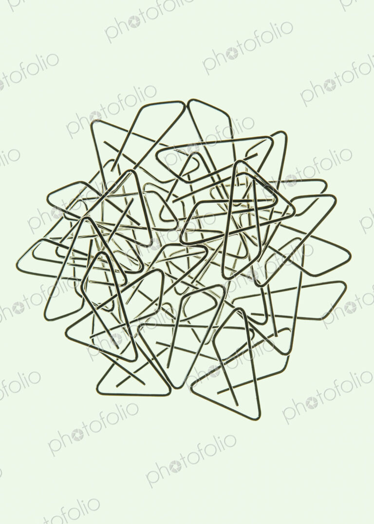 A large group of objects, a type of paperclip, metal bent into a butterfly shape on a…