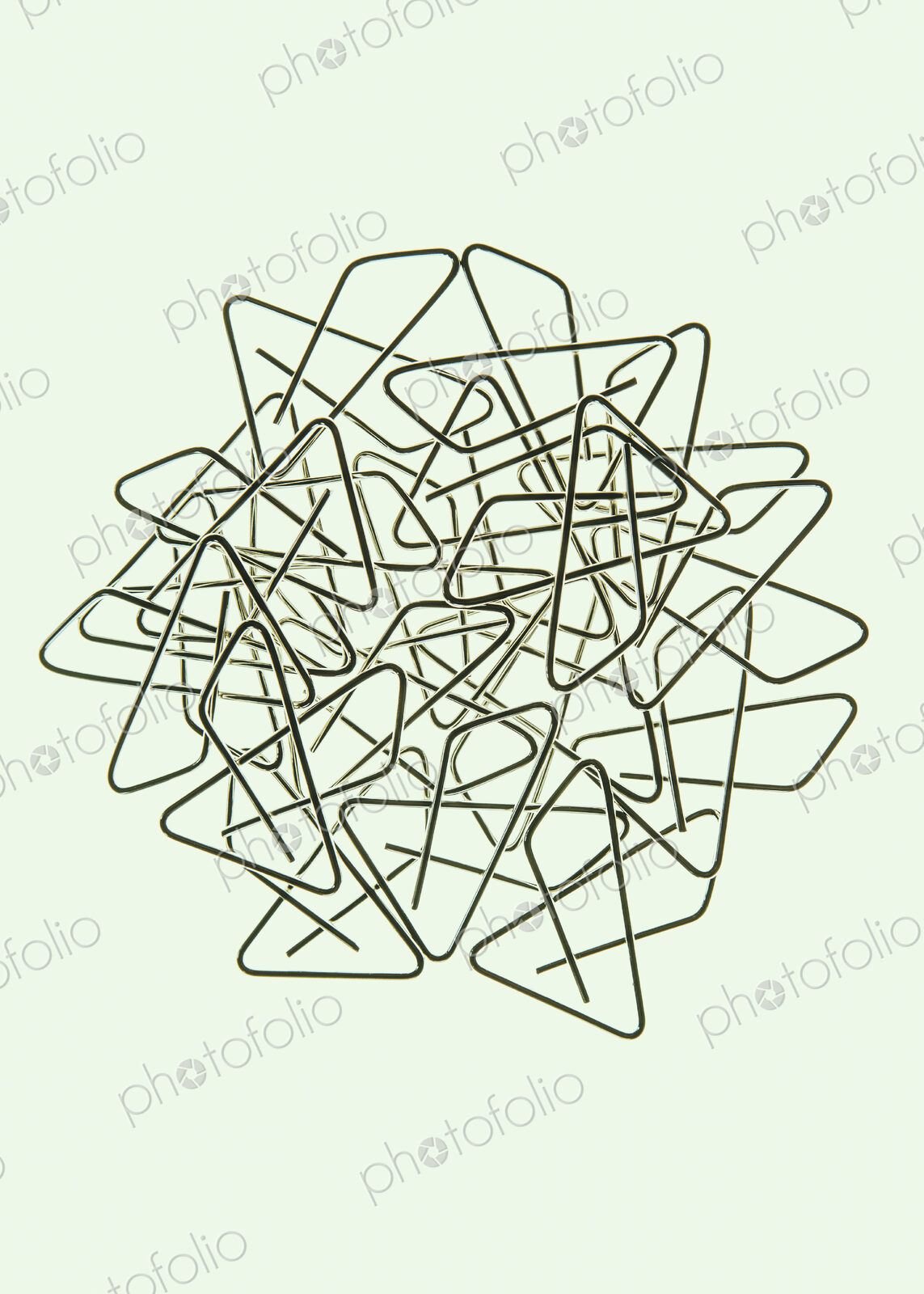 A large group of objects, a type of paperclip, metal bent into a butterfly shape on a…