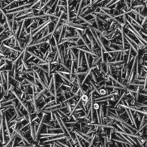 A large heap of grey metal screws, nails with a screw thread. A large heap of grey metal screws, nails with a screw thread.