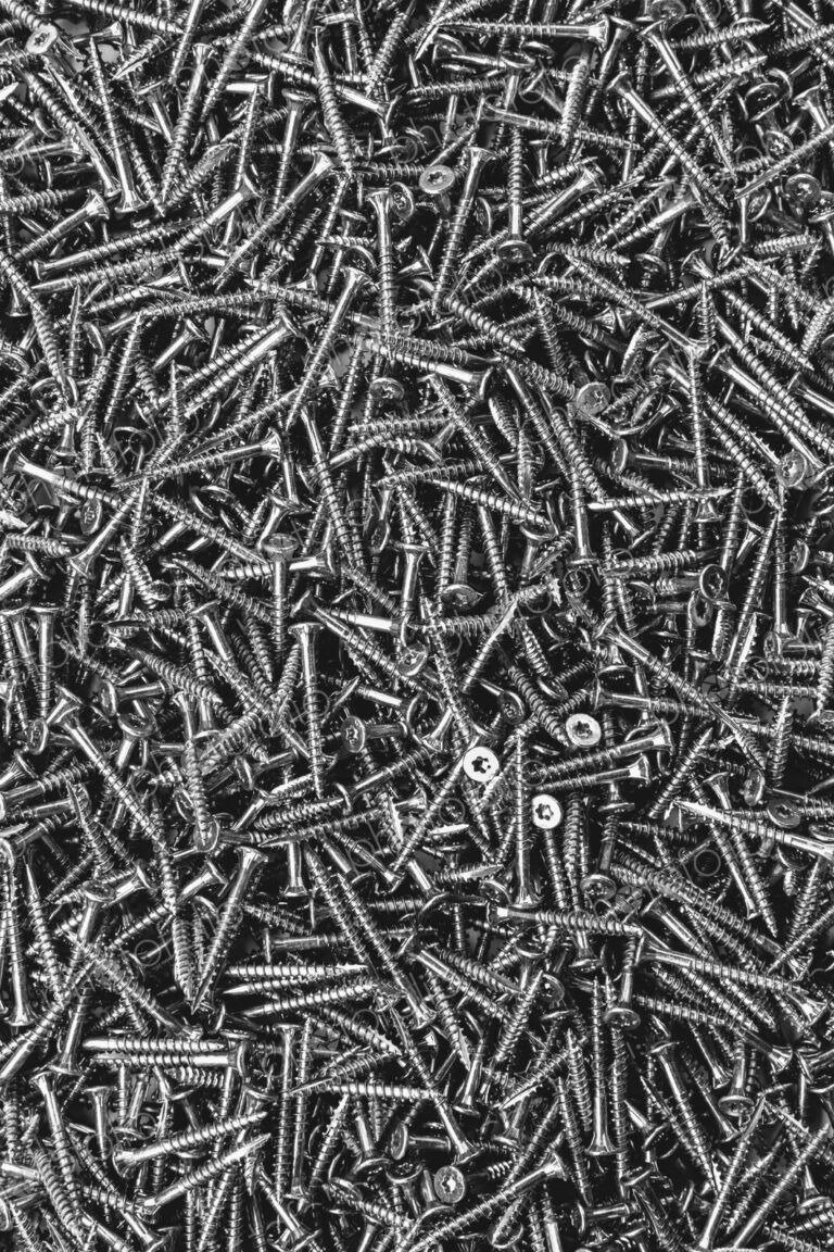 A large heap of grey metal screws, nails with a screw thread.