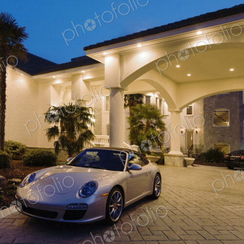 A large luxury home with sports cars.