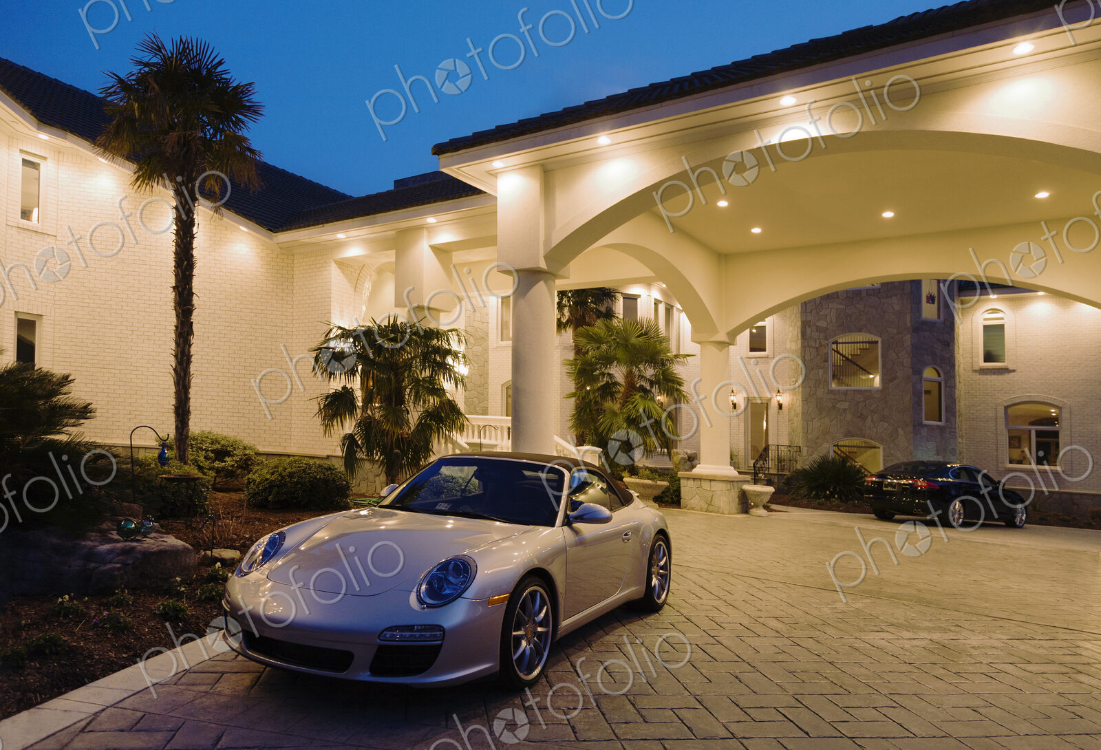A large luxury home with sports cars.