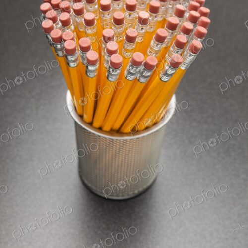 A large number of yellow No. 2 pencils in cup on desk, view from above A large number of yellow No. 2 pencils in cup on desk, view from above