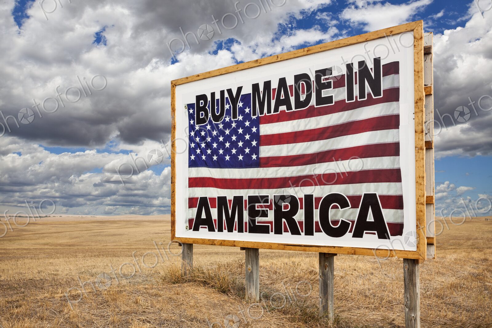 A large roadside billboard with an American flag reading Buy Made in America stands on…