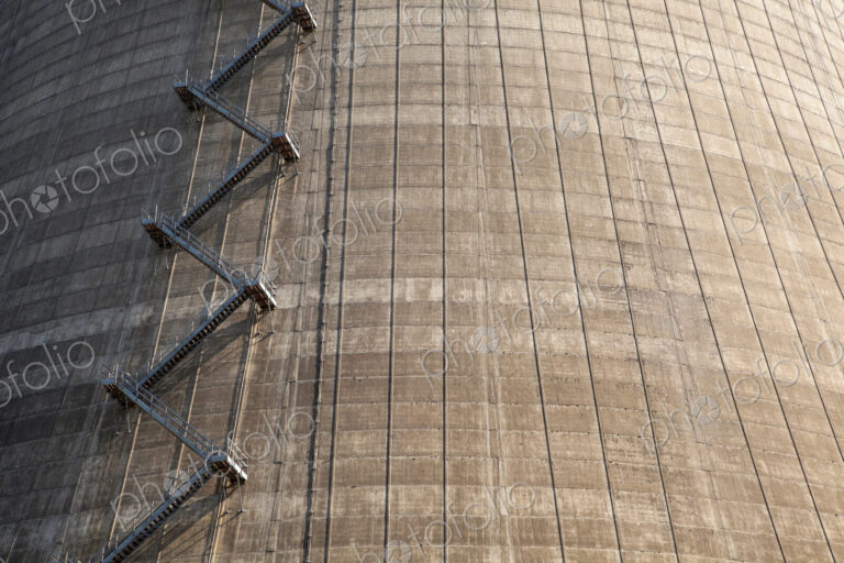 A large tower with a zigzag staircase on the side, energy production plant.