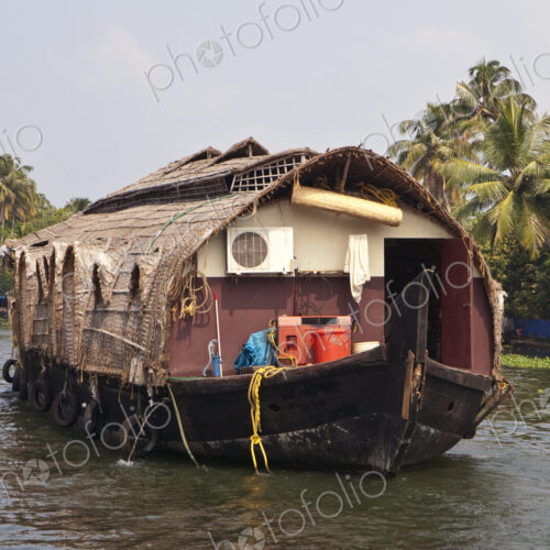 A large traditional houseboat and barge on the waters near Alleppey, India