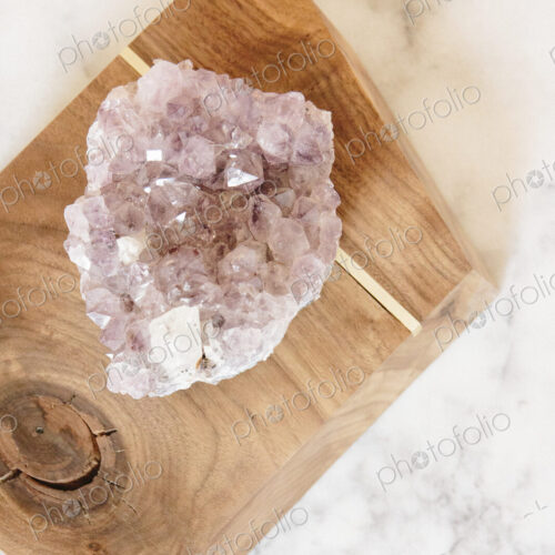A large translucent crystal on a polished wood block.