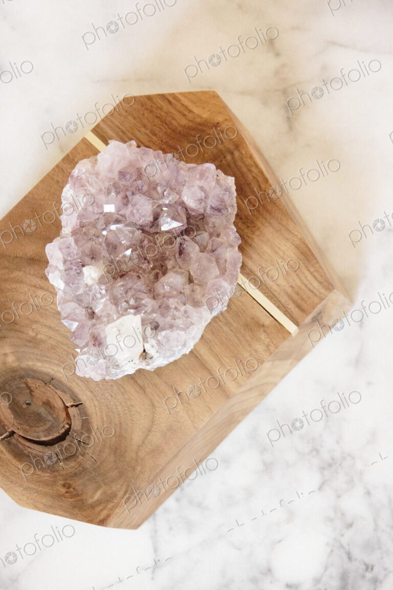A large translucent crystal on a polished wood block.