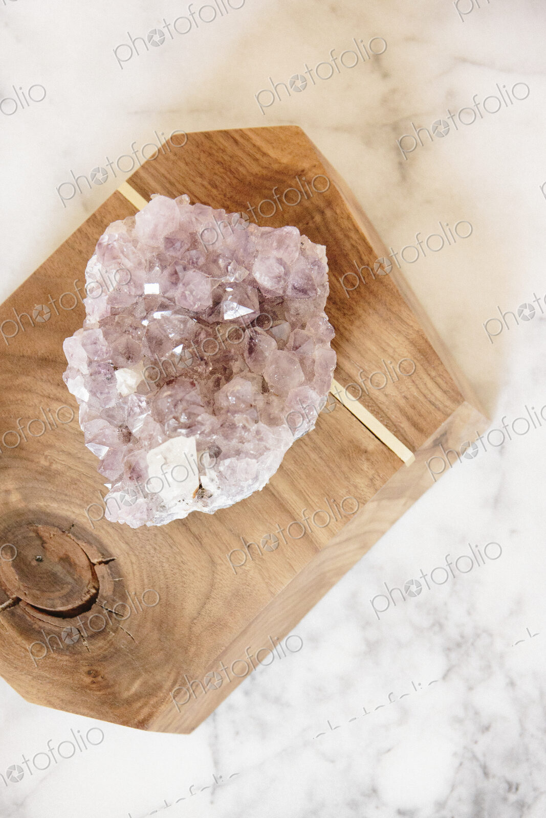 A large translucent crystal on a polished wood block.