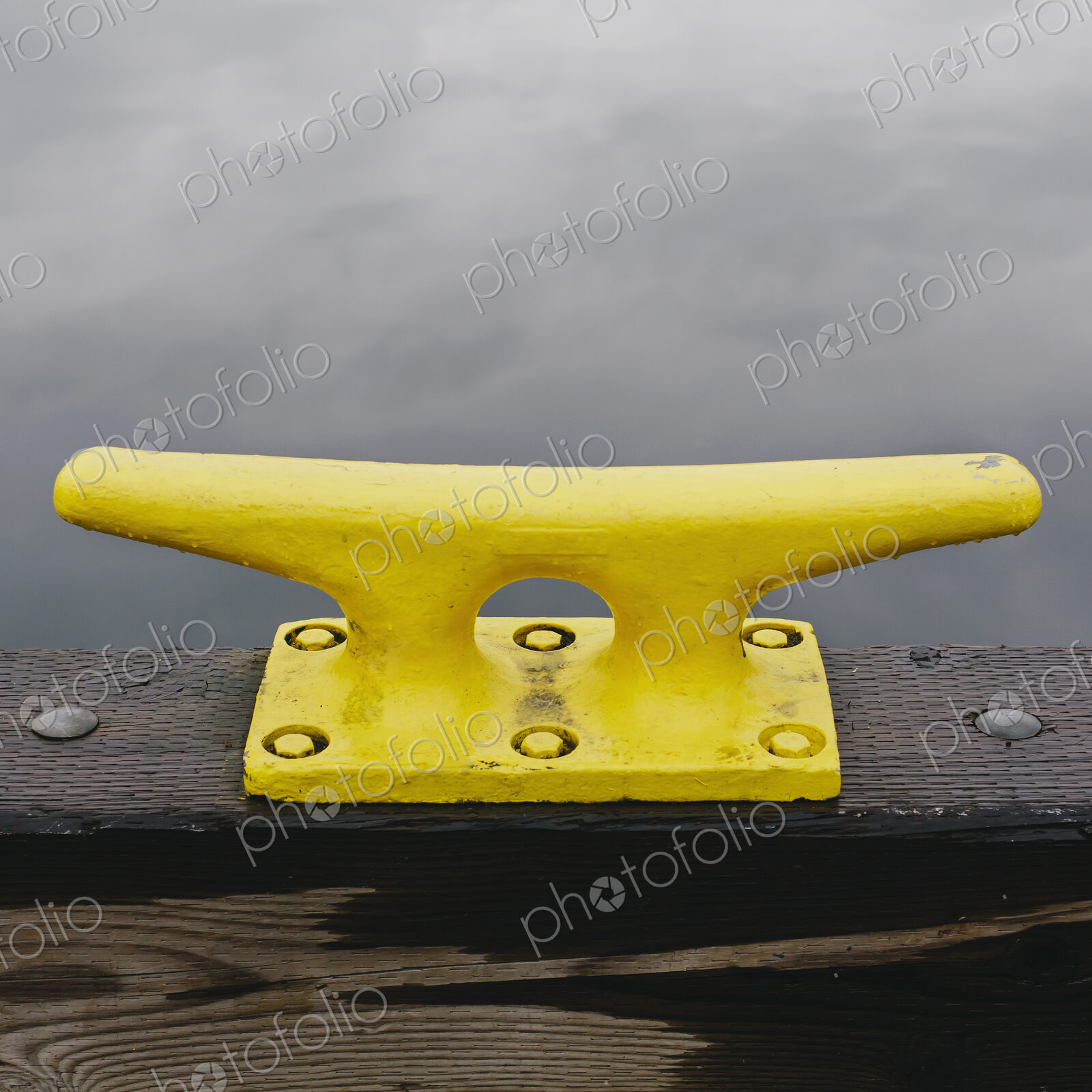 A large yellow mooring cleat on the wharfe side in Seattle.