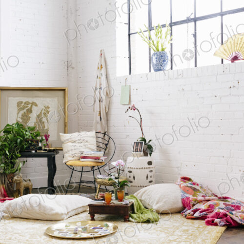 A light airy room with whitewashed walls. Cushions and possessions scattered across… A light airy room with whitewashed walls. Cushions and possessions scattered across…