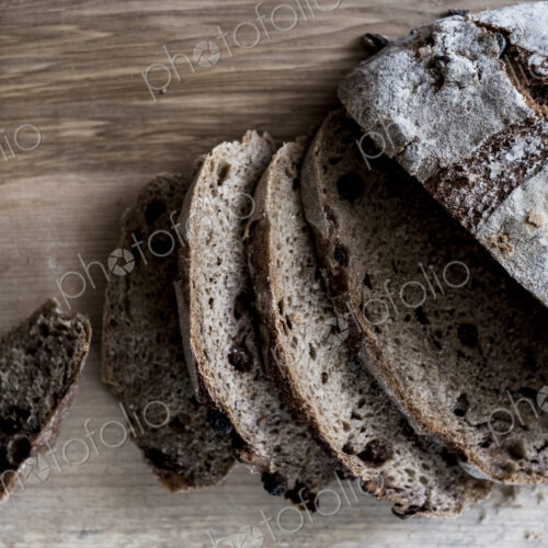 A loaf of fresh sliced brown bread on a bread board and a sharp knife A loaf of fresh sliced brown bread on a bread board and a sharp knife