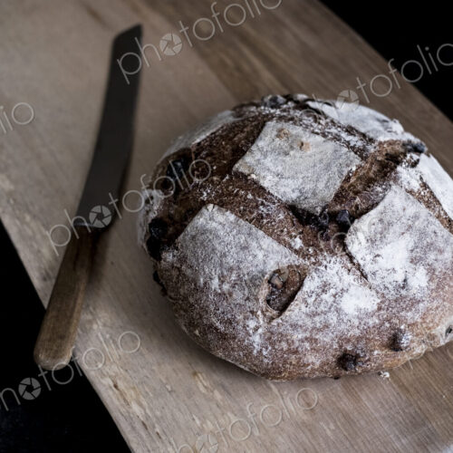 A loaf of freshly baked brown bread with a thick crust on a bread board. A loaf of freshly baked brown bread with a thick crust on a bread board.
