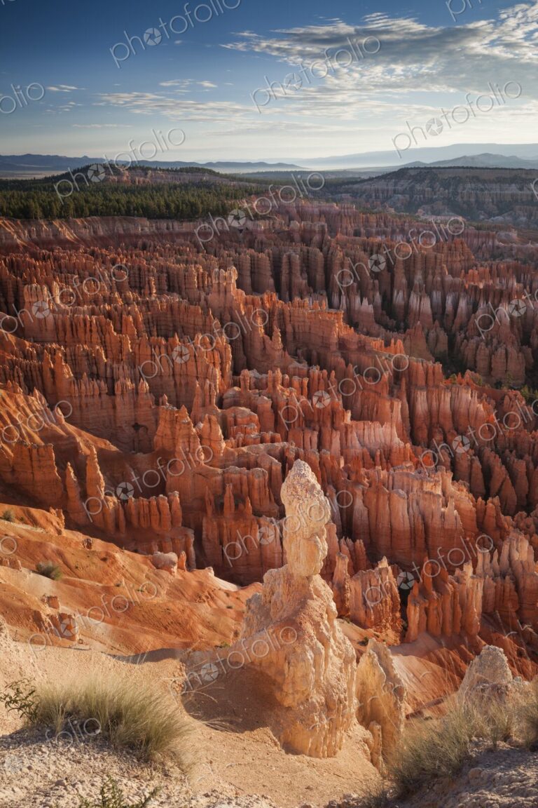 A lone hoodoo stands prominently above a sea of red rock spires at Bryce Canyon,…