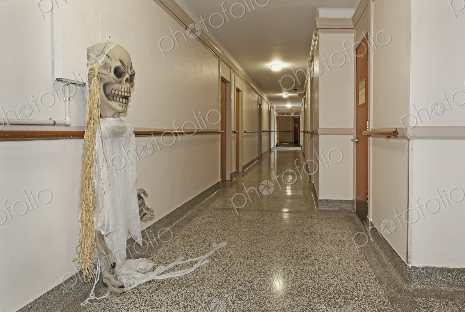 A long corridor in a building, a ghost costume hanging from a wall hook.