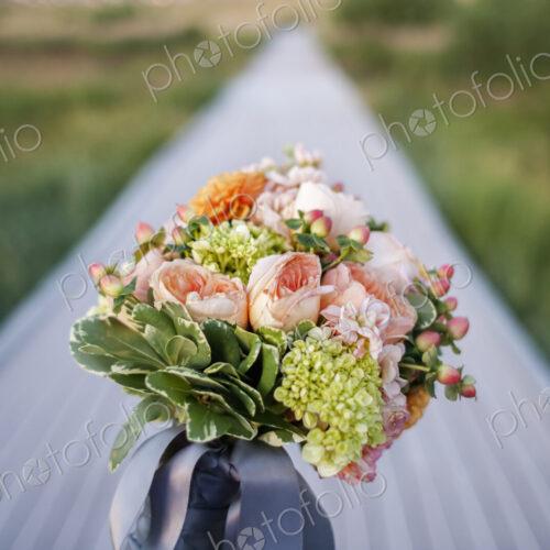 A long narrow table, with a bunch of fresh flowers in a blue vase. Table decoration. A long narrow table, with a bunch of fresh flowers in a blue vase. Table decoration.
