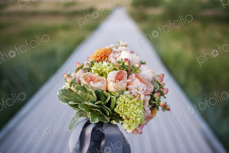 A long narrow table, with a bunch of fresh flowers in a blue vase. Table decoration.
