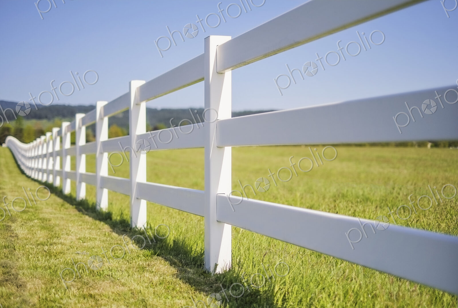 A long white farm fence in countryside surrounding pasture, Hockinson, Washington, USA.